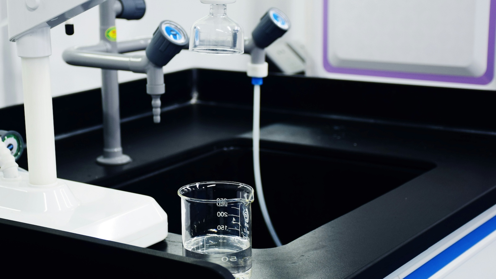 A clear glass of drinking water on a kitchen counter beside a water-testing report — representing informed, evidence-based filter choices.