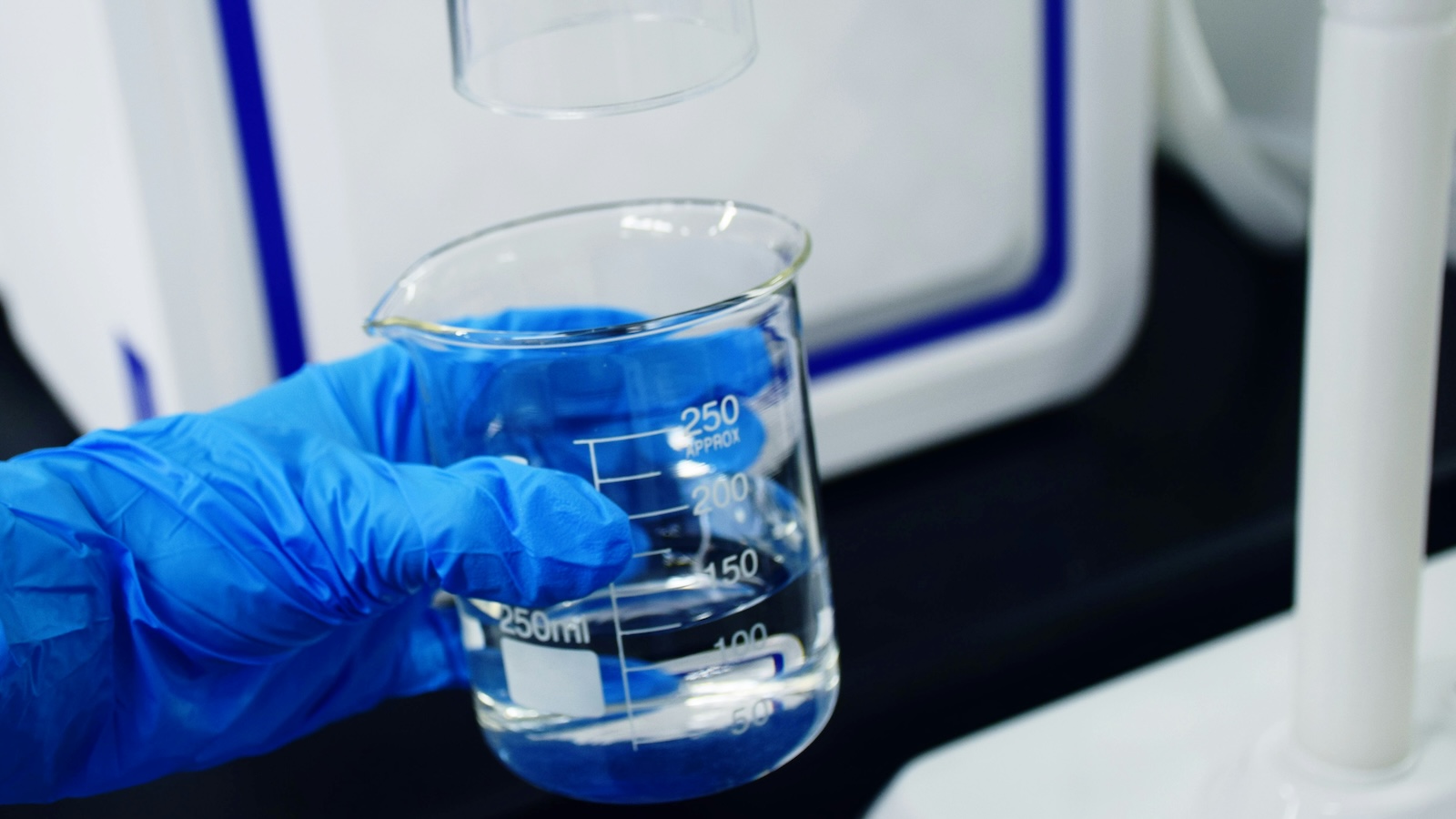 A certification database listing open on a screen next to a water filter — illustrating verification of a finished product against a published standard.