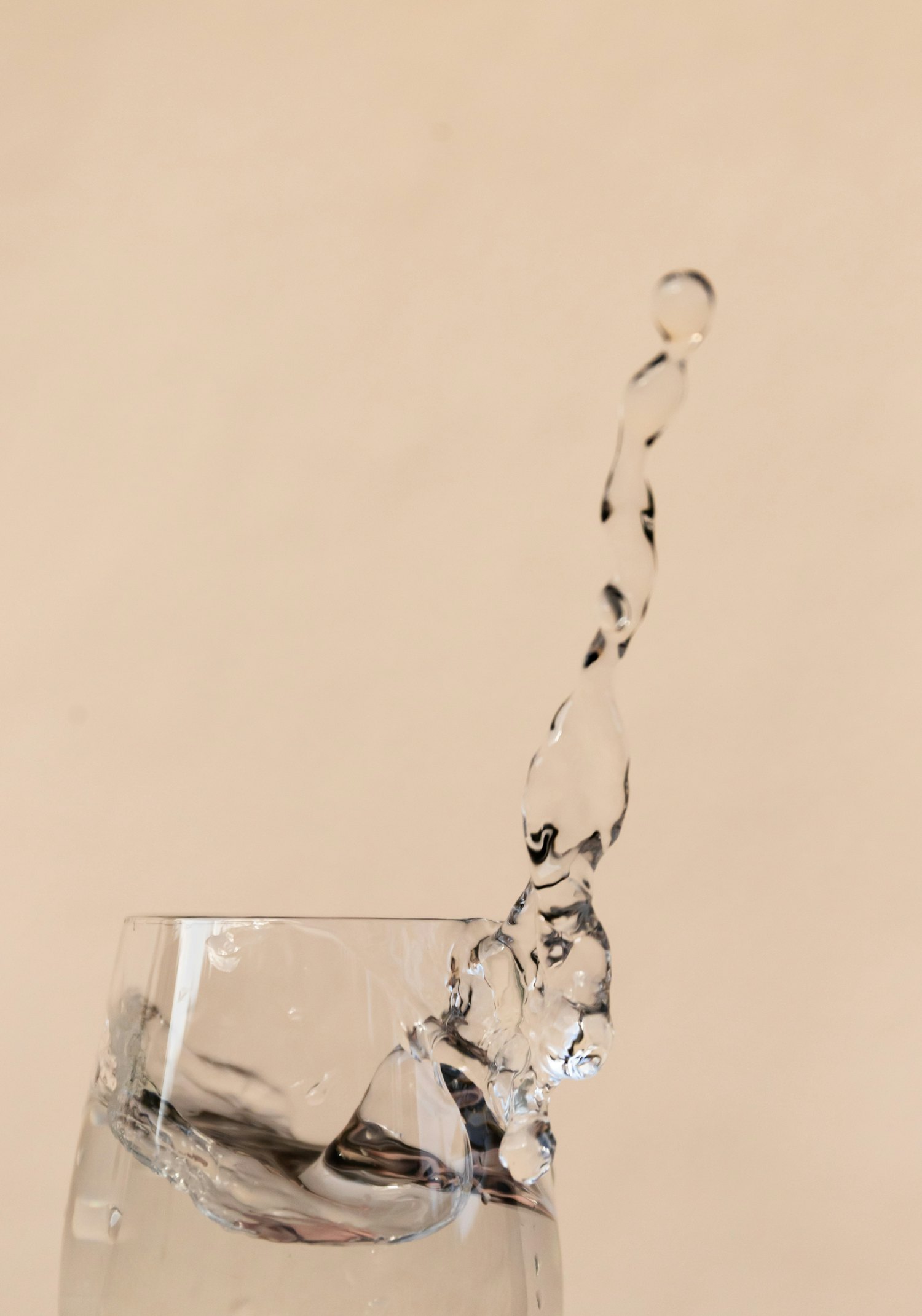 Water splashing in a clear drinking glass — PFAS are odorless and tasteless in water and are reduced most effectively at the tap you drink from.