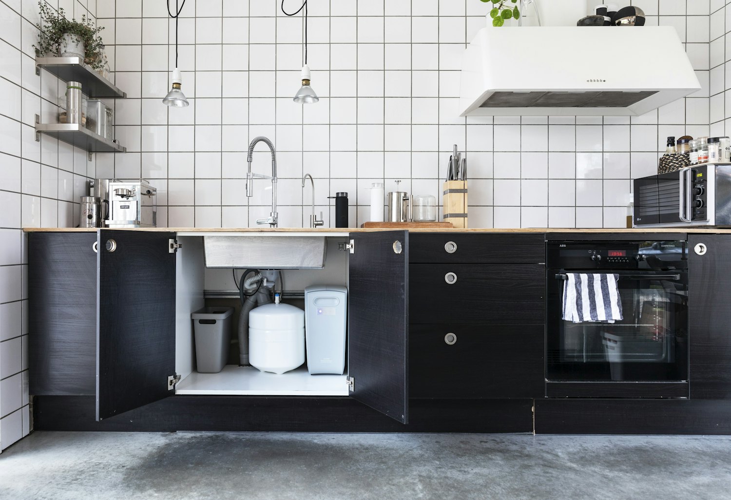 An under-sink cabinet where a reverse-osmosis drinking-water system is typically installed at the point of use.